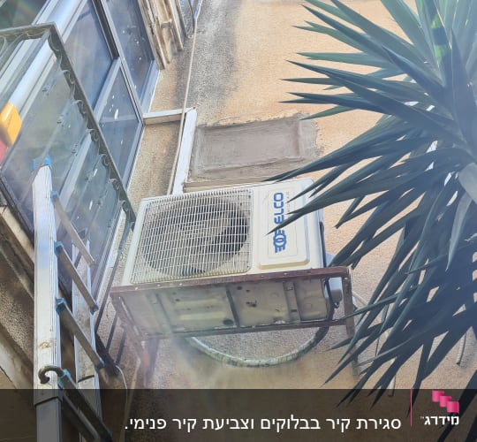 מזגן מותקן על קיר חיצוני ליד סולם